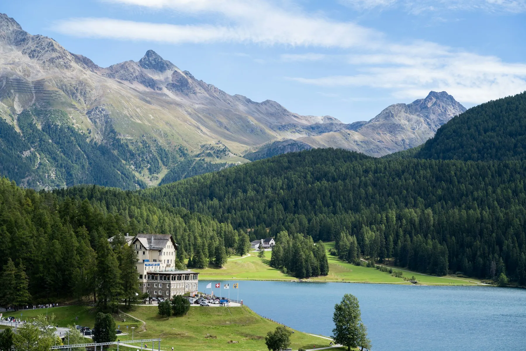 A grand lakeside hotel framed by Alpine mountains