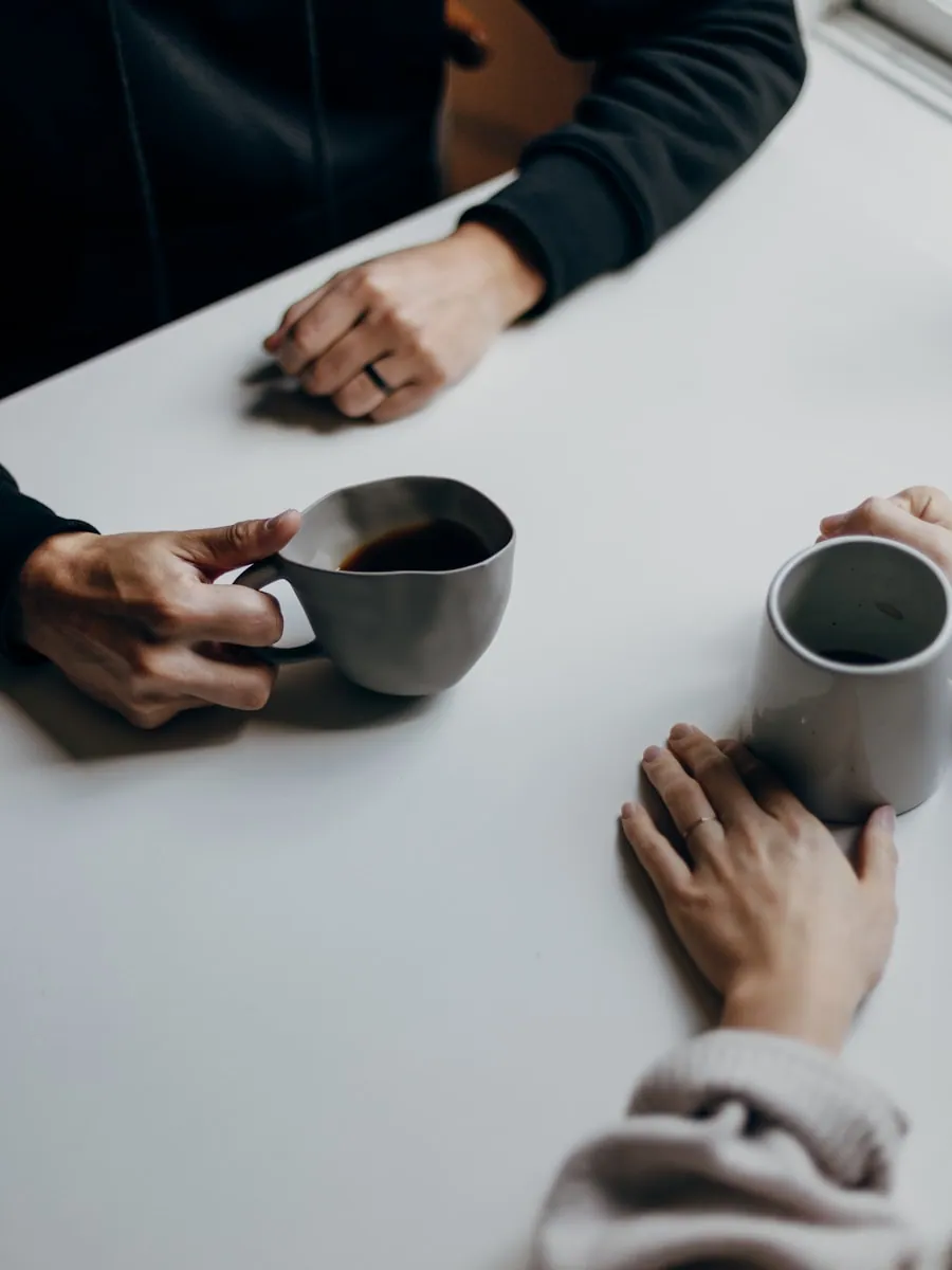 Two people having a relaxed conversation over coffee