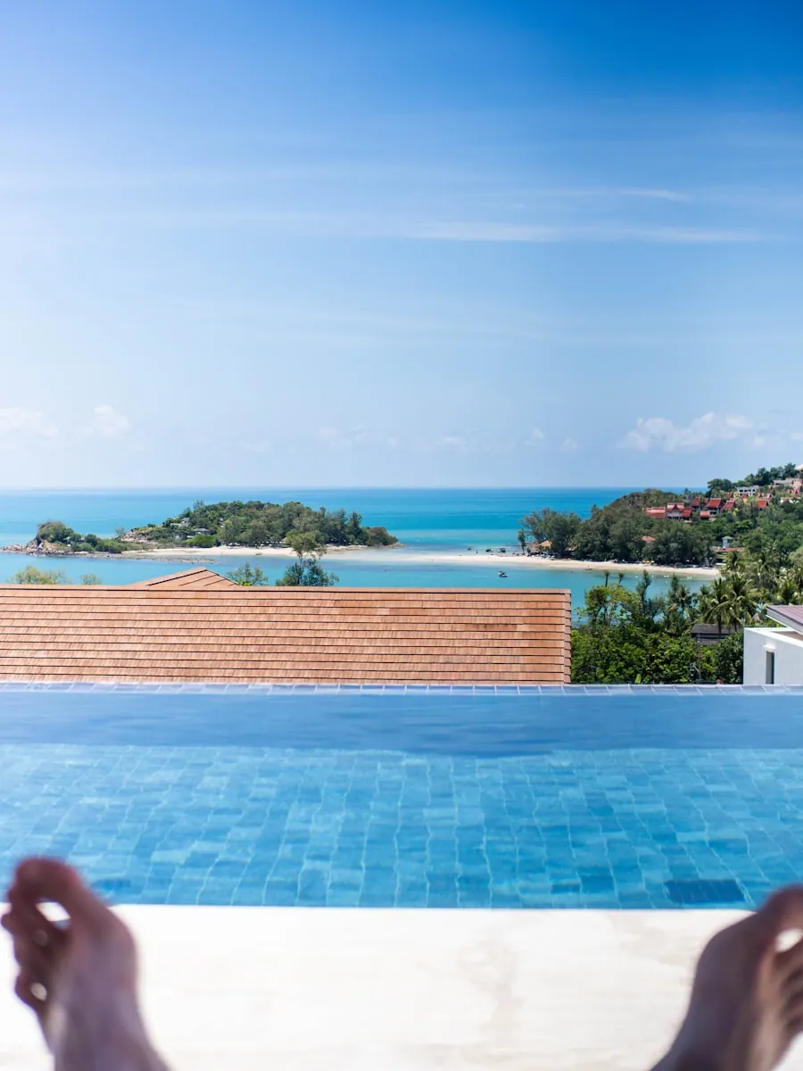 A traveler relaxing at an infinity pool overlooking the ocean